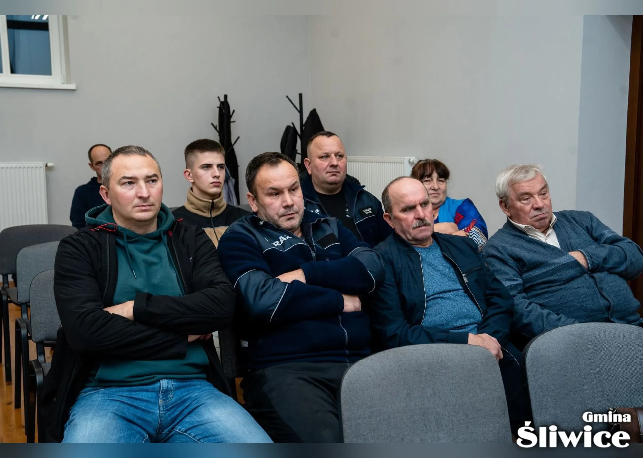 zebrani siedzą na krzesłach