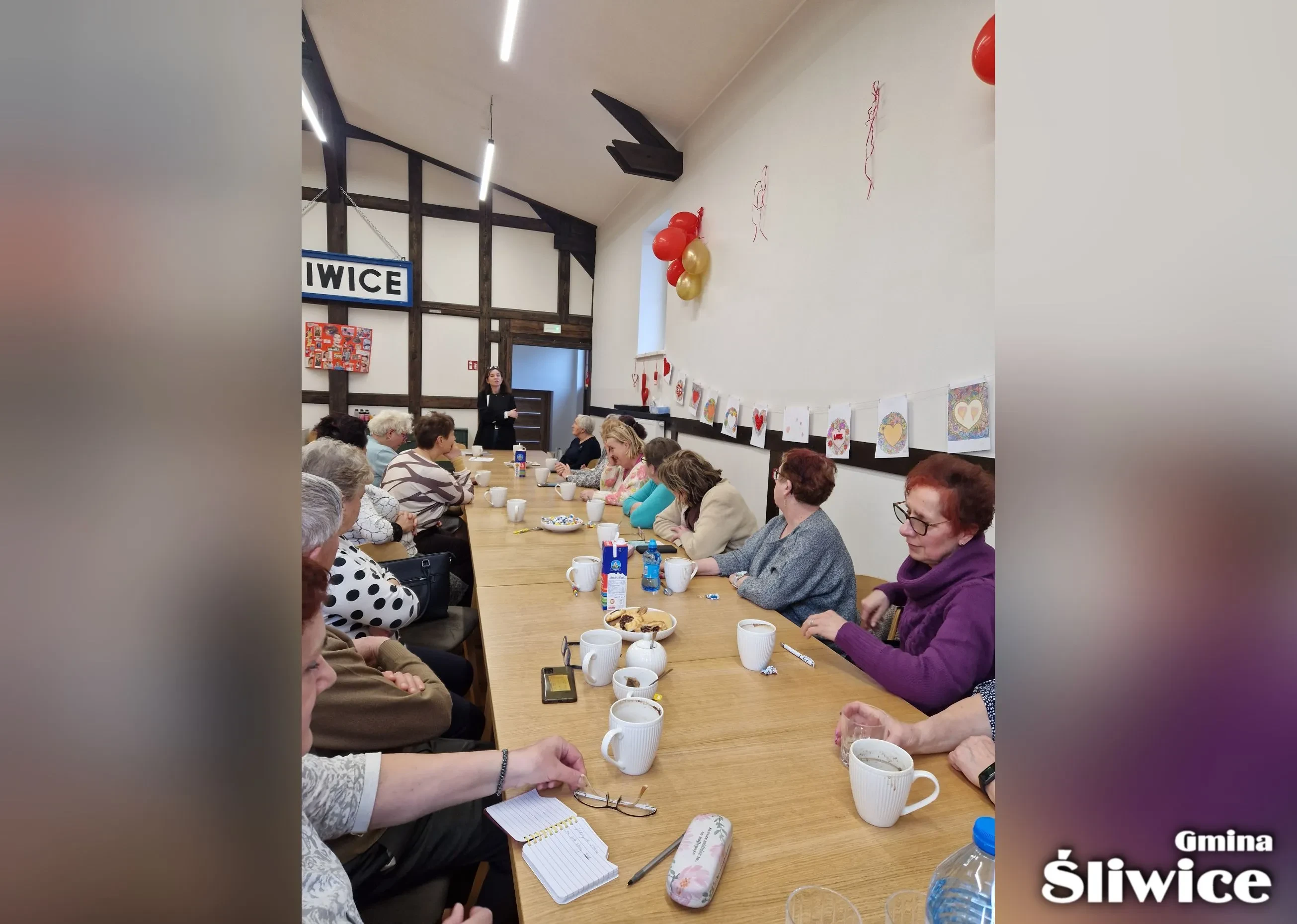 zebrani siedza przy stołach i słuchają