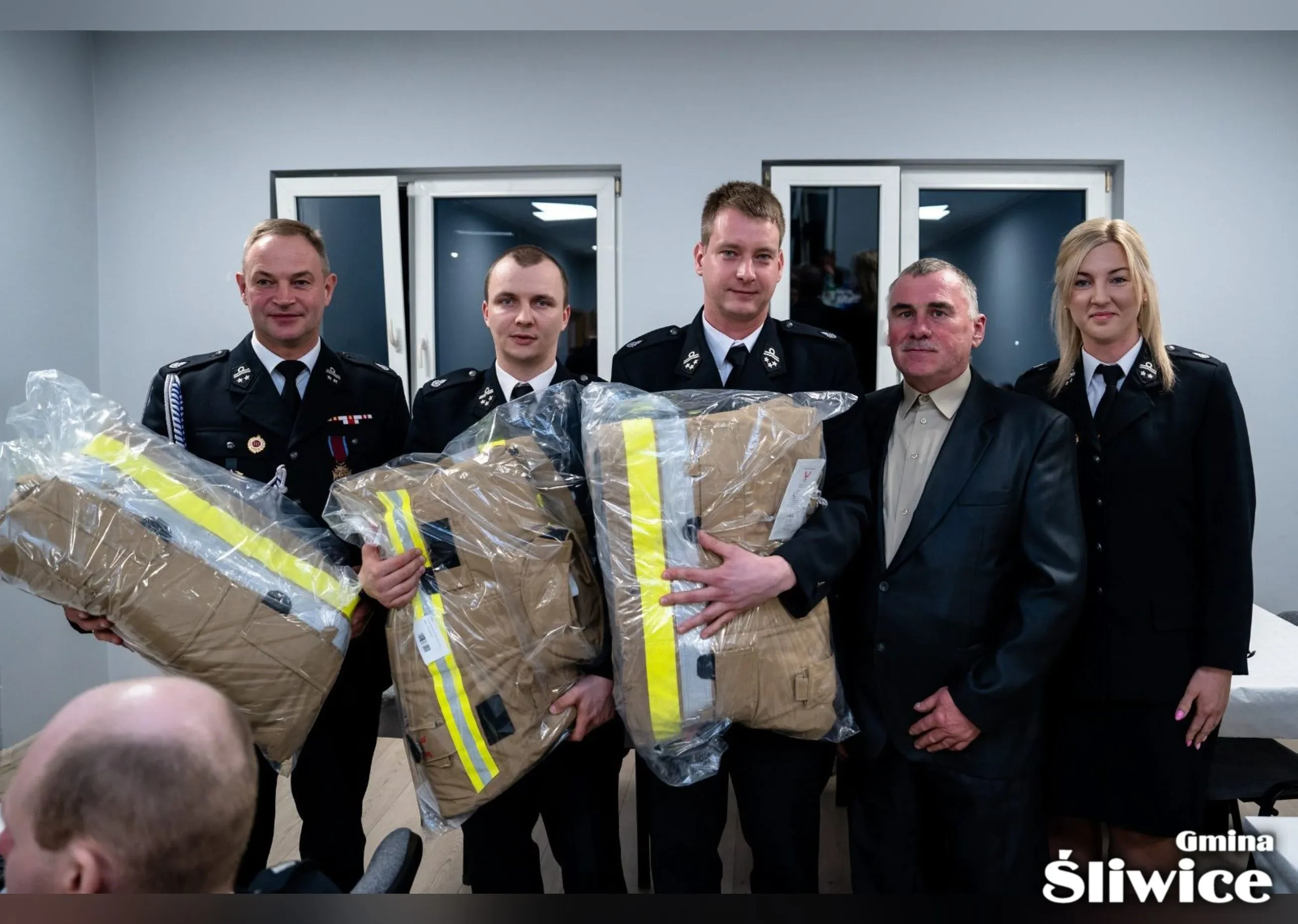 wójt, wicewójt, sołtys i reprezentanci osp śliwice pozują do zdjęcia z nowymi przedmiotami dla osp