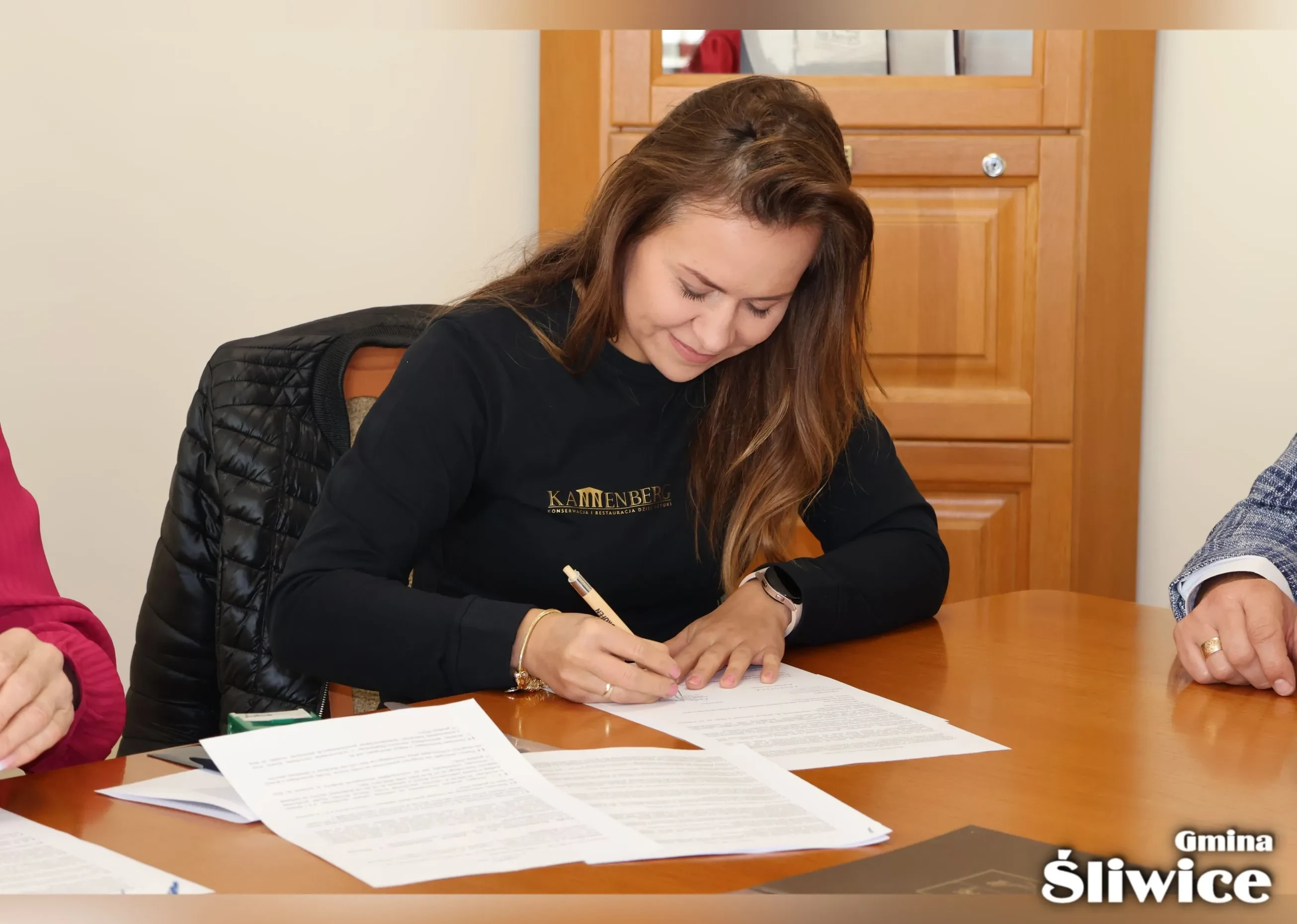 przedstawicielka firmy podpisuje umowę
