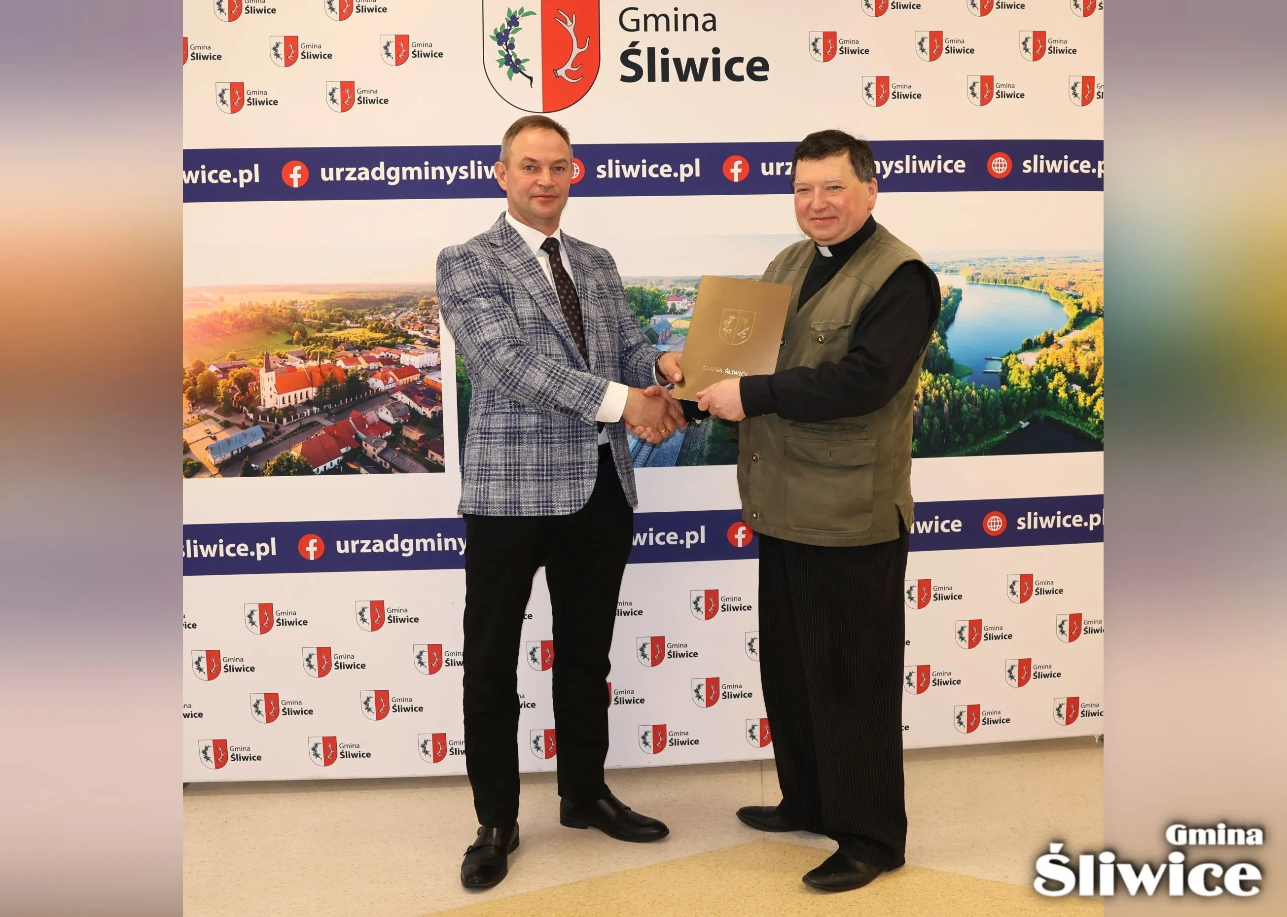 wójt i proboszcz pozują z umową